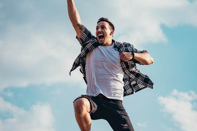 Foto de um homem saltando no ar, feliz, como se tivesse tido sucesso em algo. A foto ilustra o artigo Por que desconstruir os seus padrões comportamentais por meio da sua aceitação e da sua transformação escrito pelo psicanalista Homero Mônaco para o site Online Psicanalista.